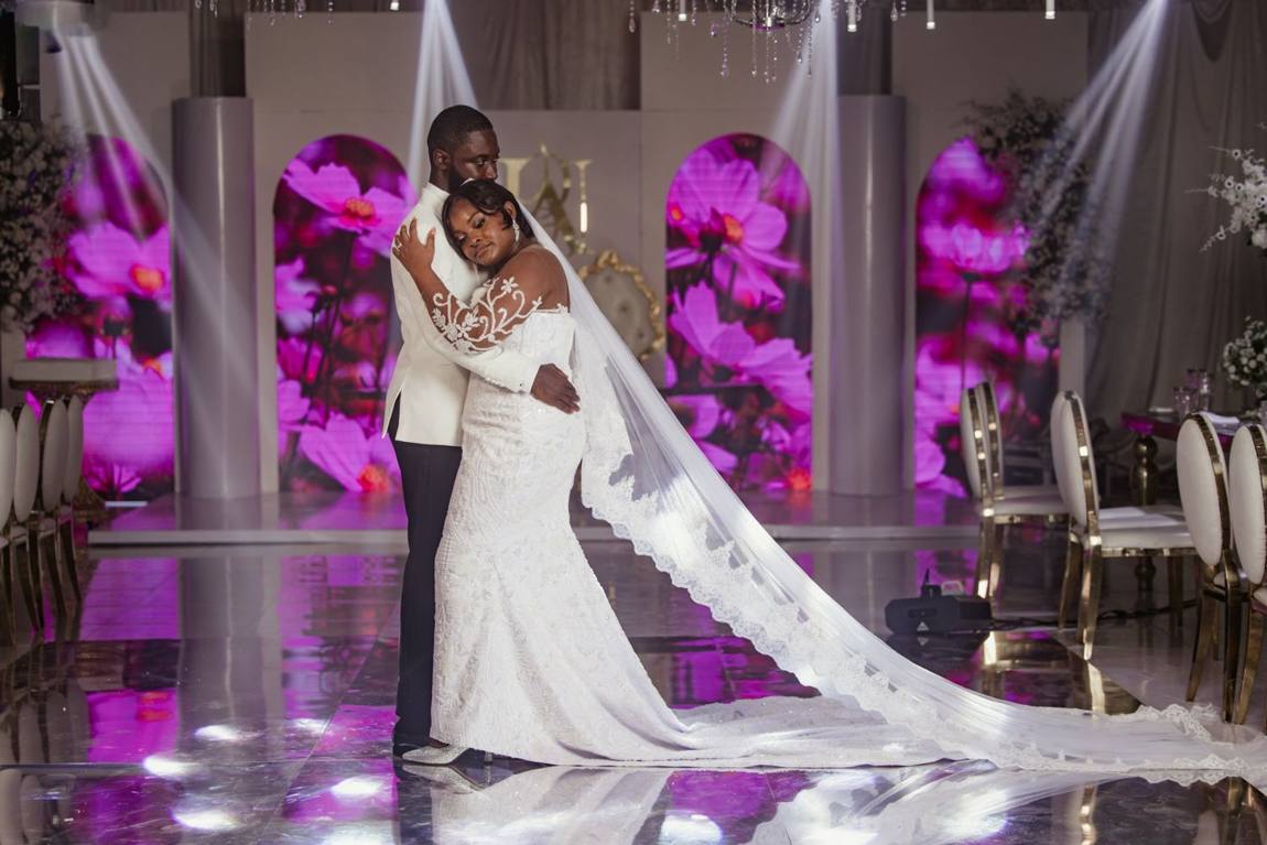 Couple sharing their first dance under purple lights